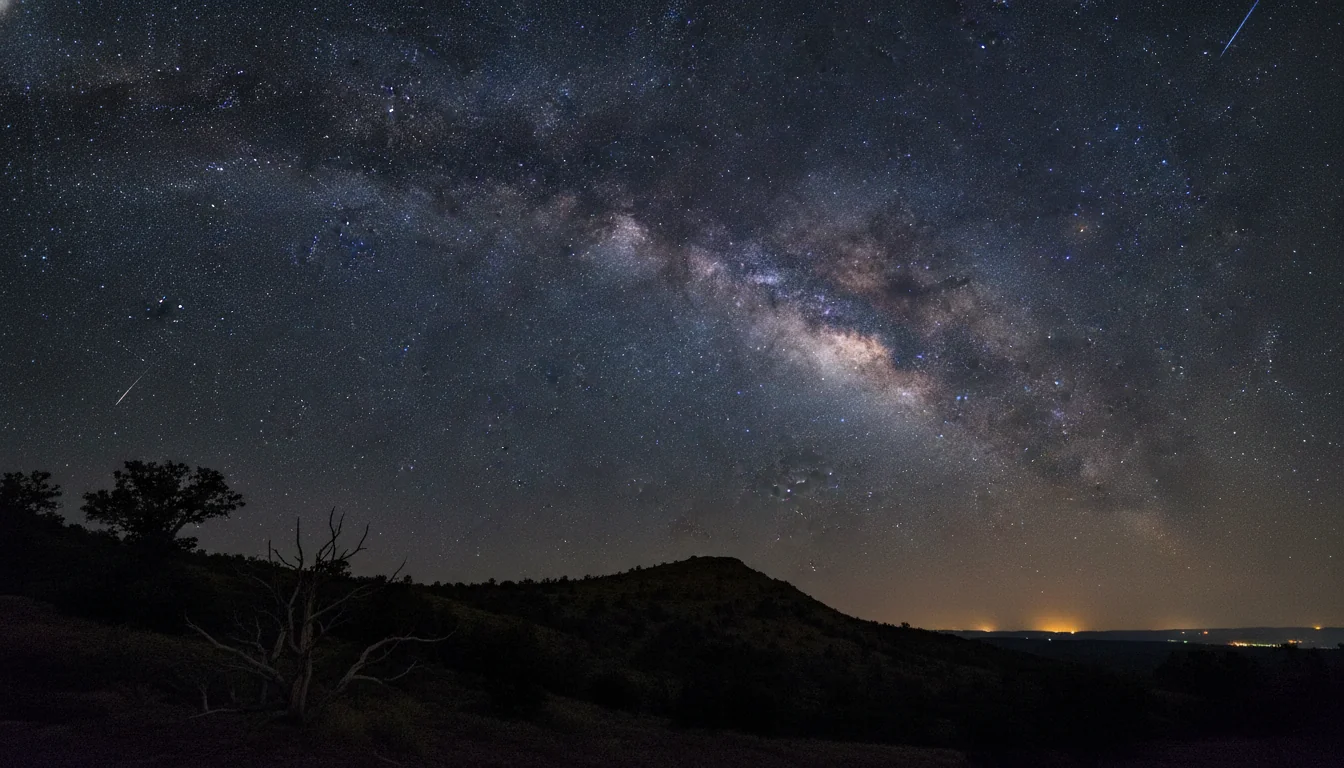 Bright Perseid meteors streaking across a dark August sky above a quiet hillside with the constellation Perseus rising in the northeast